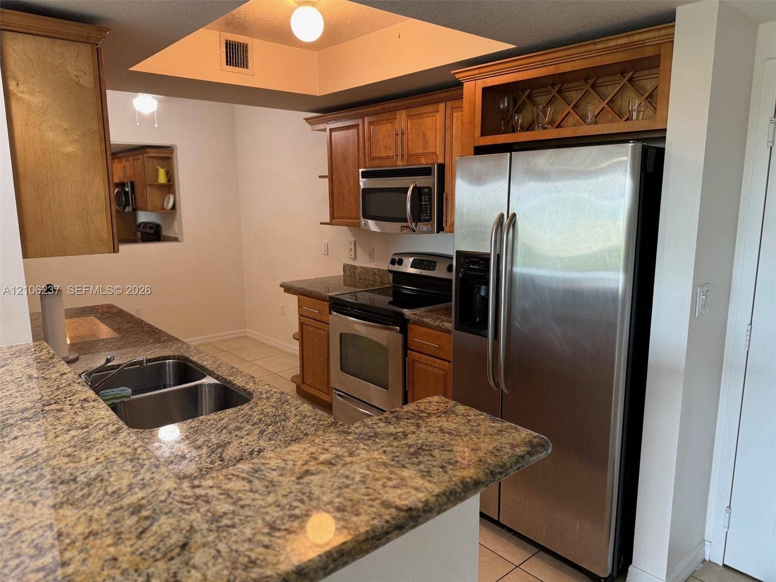 3530 SW 22nd Street, #706, Miami, Miami, FL 33145 Kitchen featuring stone countertops, stainless steel appliances, wood cabinetry, integrated wine storage, and a dual-basin sink