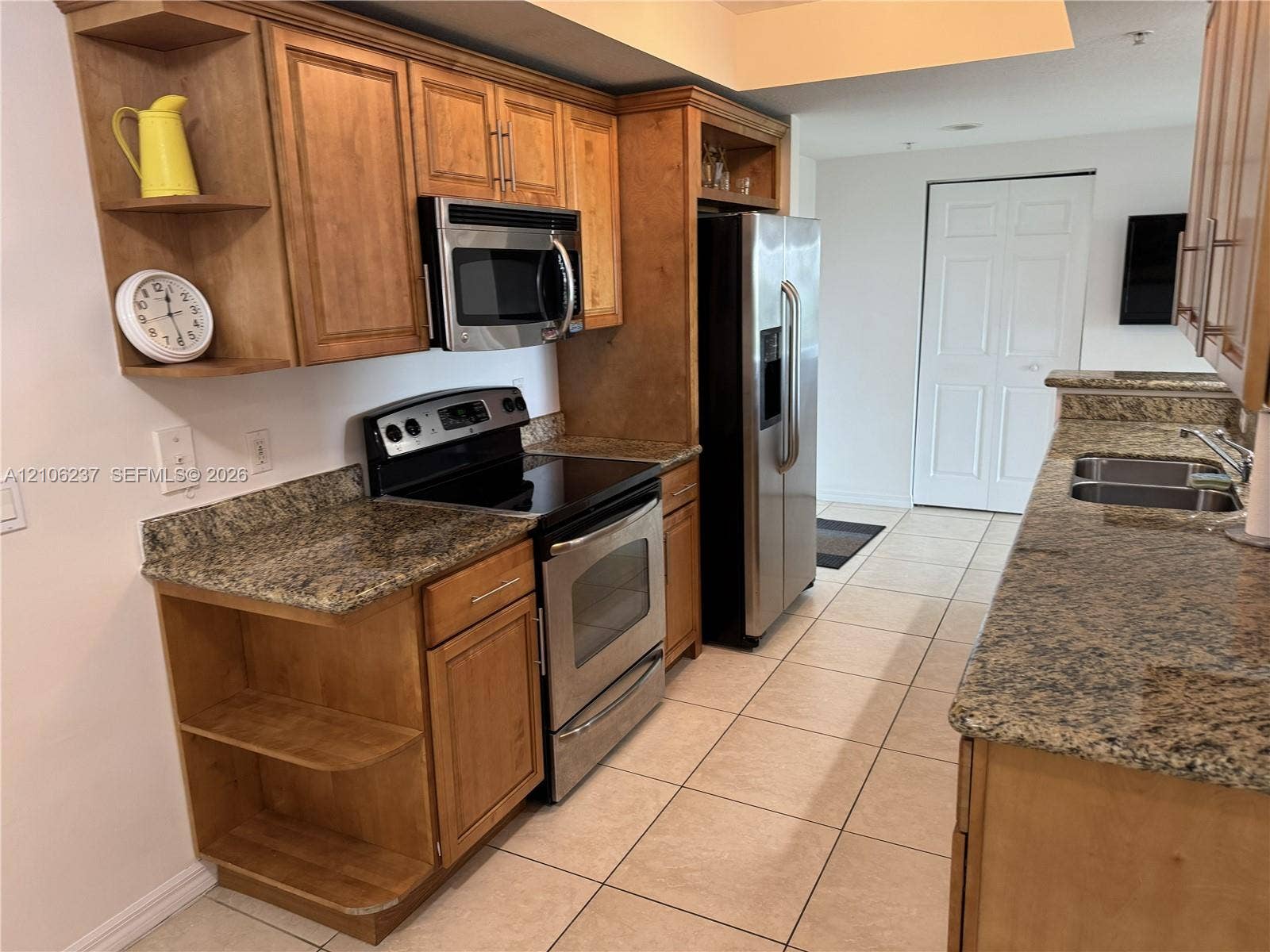 3530 SW 22nd Street, #706, Miami, Miami, FL 33145 Kitchen featuring stained wood cabinetry, stone countertops, stainless steel appliances, and ceramic tile flooring