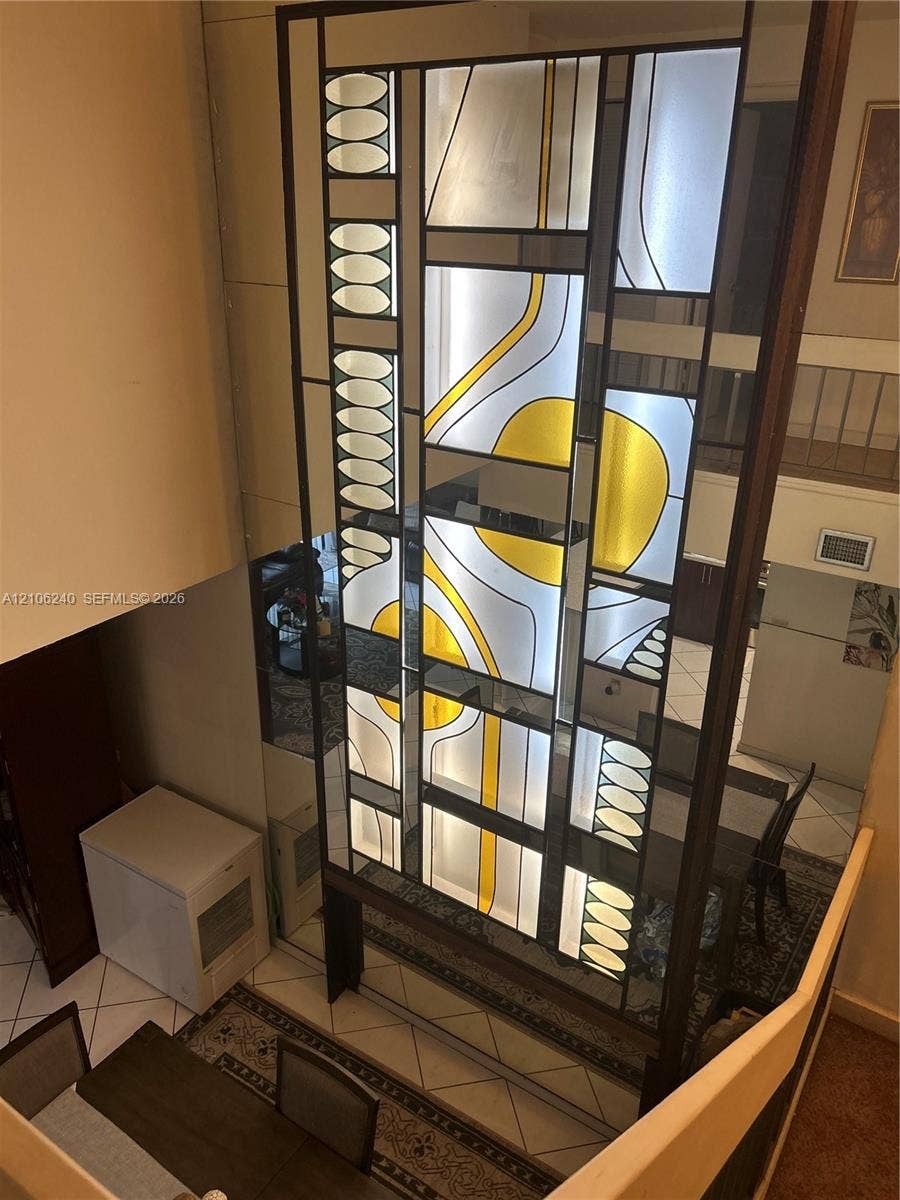 2554 N 38th Avenue, Hollywood, FL 33021 Custom floor-to-ceiling geometric stained glass screen featuring a dark metal frame and abstract yellow and frosted glass inserts