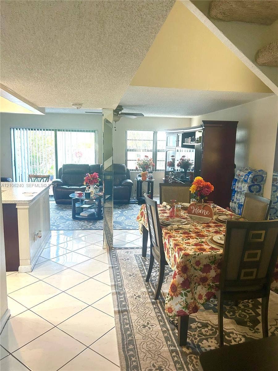 2554 N 38th Avenue, Hollywood, FL 33021 Open floor plan featuring white tile flooring, vaulted ceilings, and a mirrored pillar accent