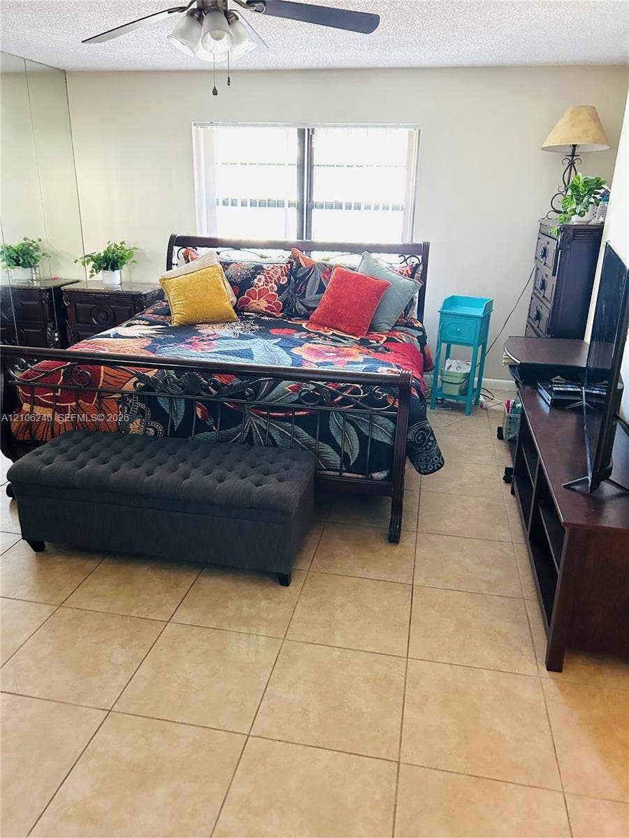 2554 N 38th Avenue, Hollywood, FL 33021 Neutral-toned tile flooring, mirrored wall paneling, and a ceiling-mounted fan with light fixture