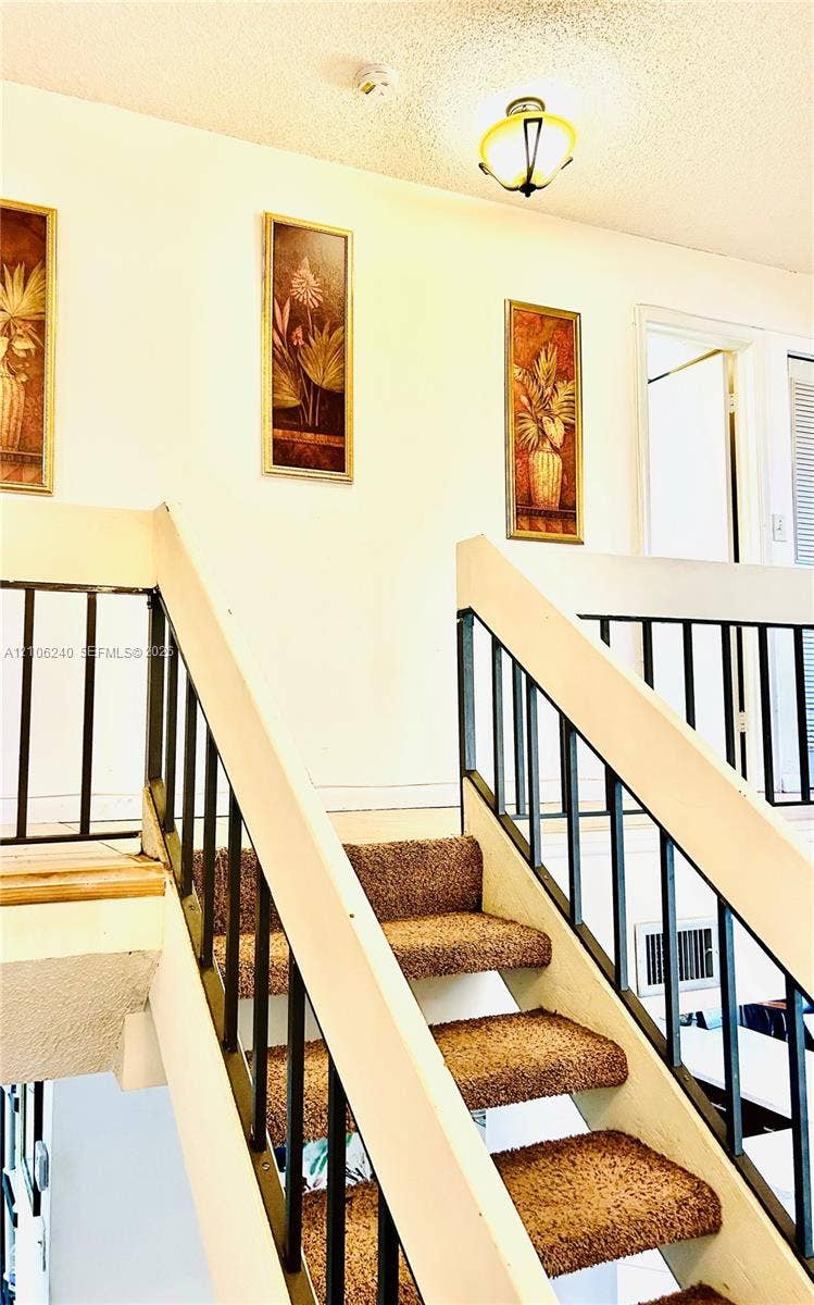 2554 N 38th Avenue, Hollywood, FL 33021 Staircase featuring carpeted treads and metal balustrades, complemented by a flush-mount ceiling light fixture