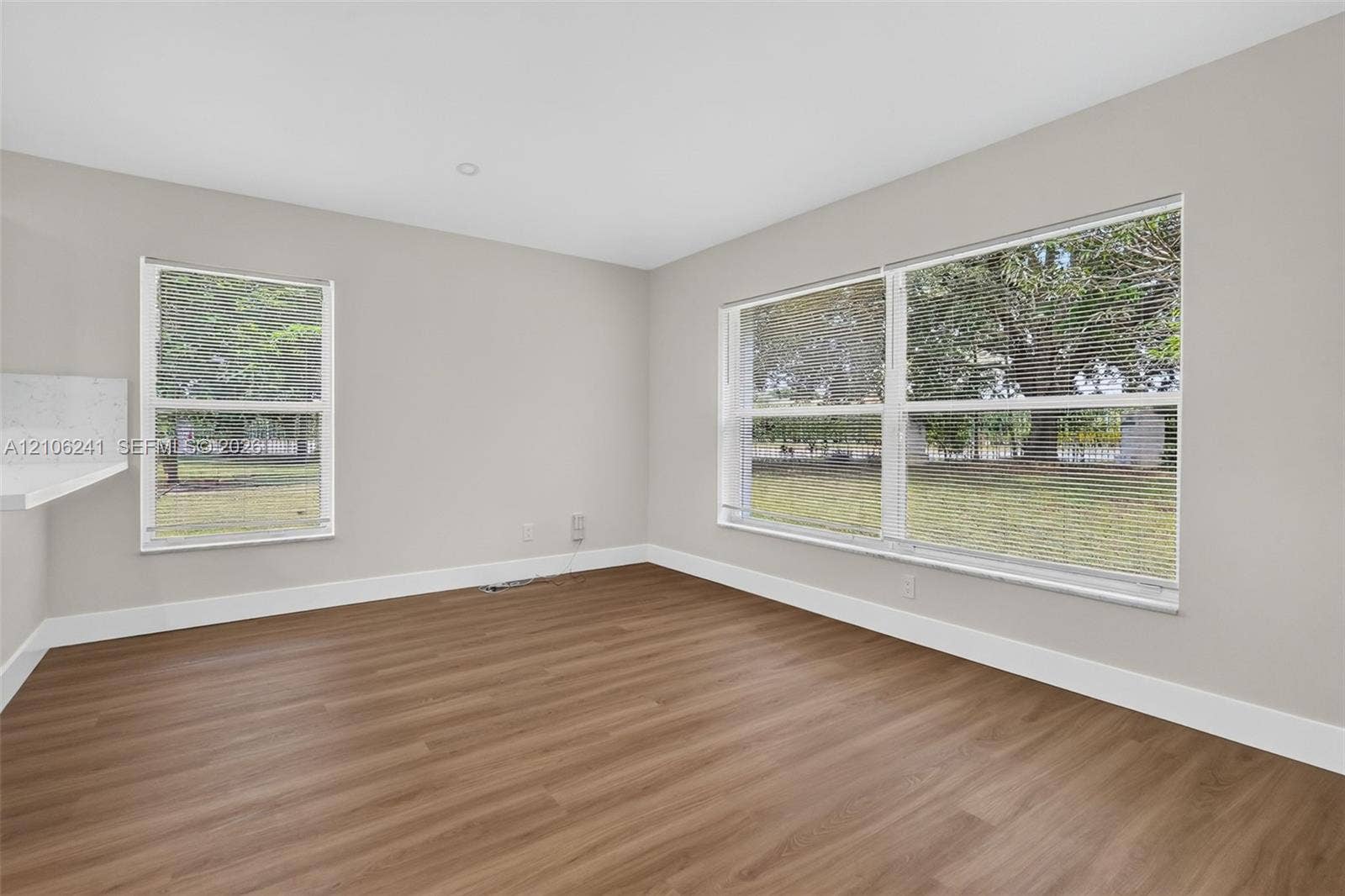 9407 SW 18th Street, Miramar, FL 33025 Neutral-toned interior space featuring wood-finish flooring, recessed lighting, and expansive windows