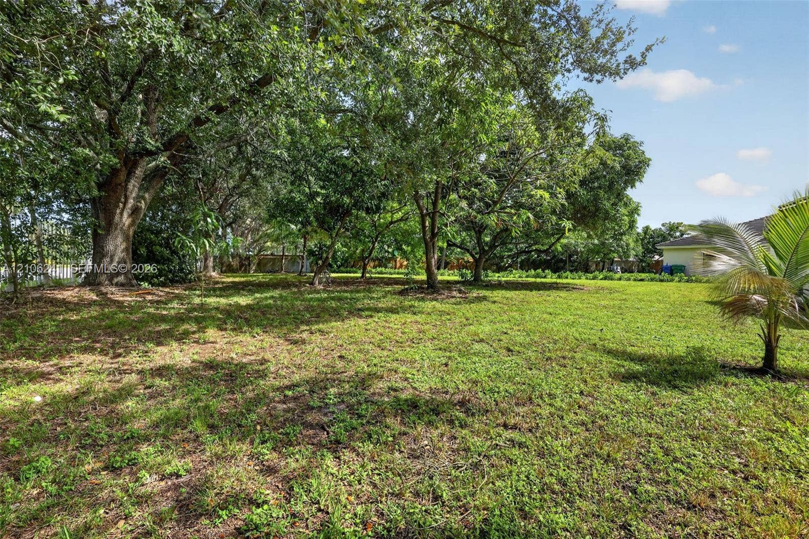 9407 SW 18th Street, Miramar, FL 33025 Expansive backyard featuring mature shade trees, established landscaping, and a perimeter fence