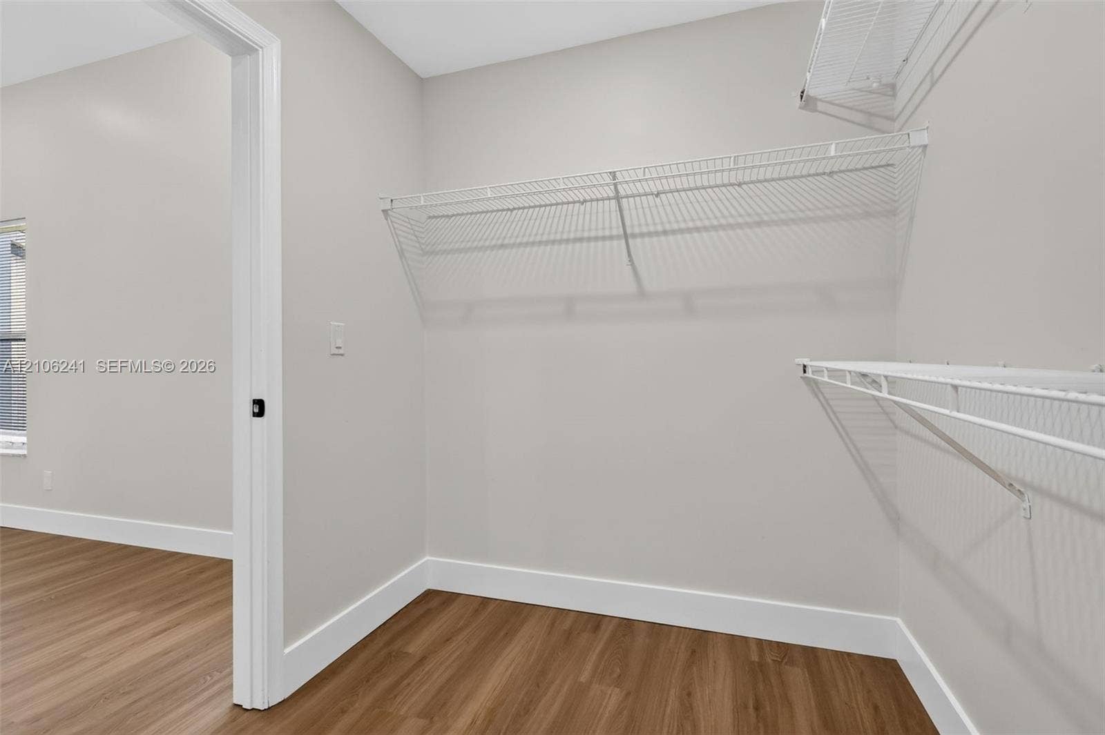 9407 SW 18th Street, Miramar, FL 33025 Walk-in closet featuring neutral walls, wood-finish flooring, and tiered white wire shelving