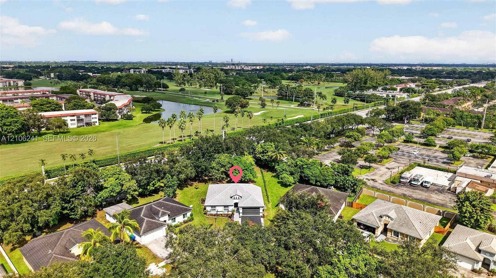 9407 SW 18th Street, Miramar, FL 33025 Aerial perspective of single-story residence featuring a hipped roof, attached garage, mature landscaping, and an expansive lot