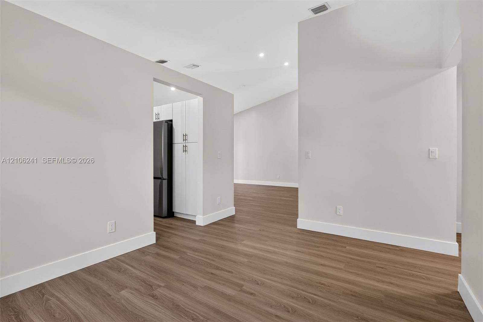 9407 SW 18th Street, Miramar, FL 33025 Vaulted ceilings, wood-finish flooring, recessed lighting, and white cabinetry