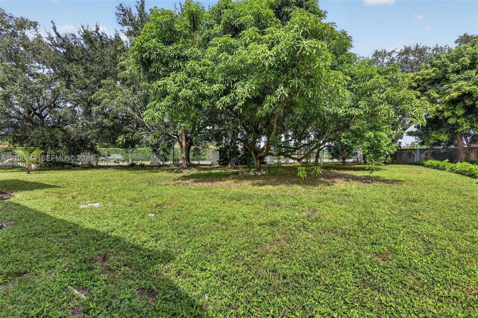 9407 SW 18th Street, Miramar, FL 33025 Expansive lot featuring mature shade trees, a grass lawn, and perimeter fencing