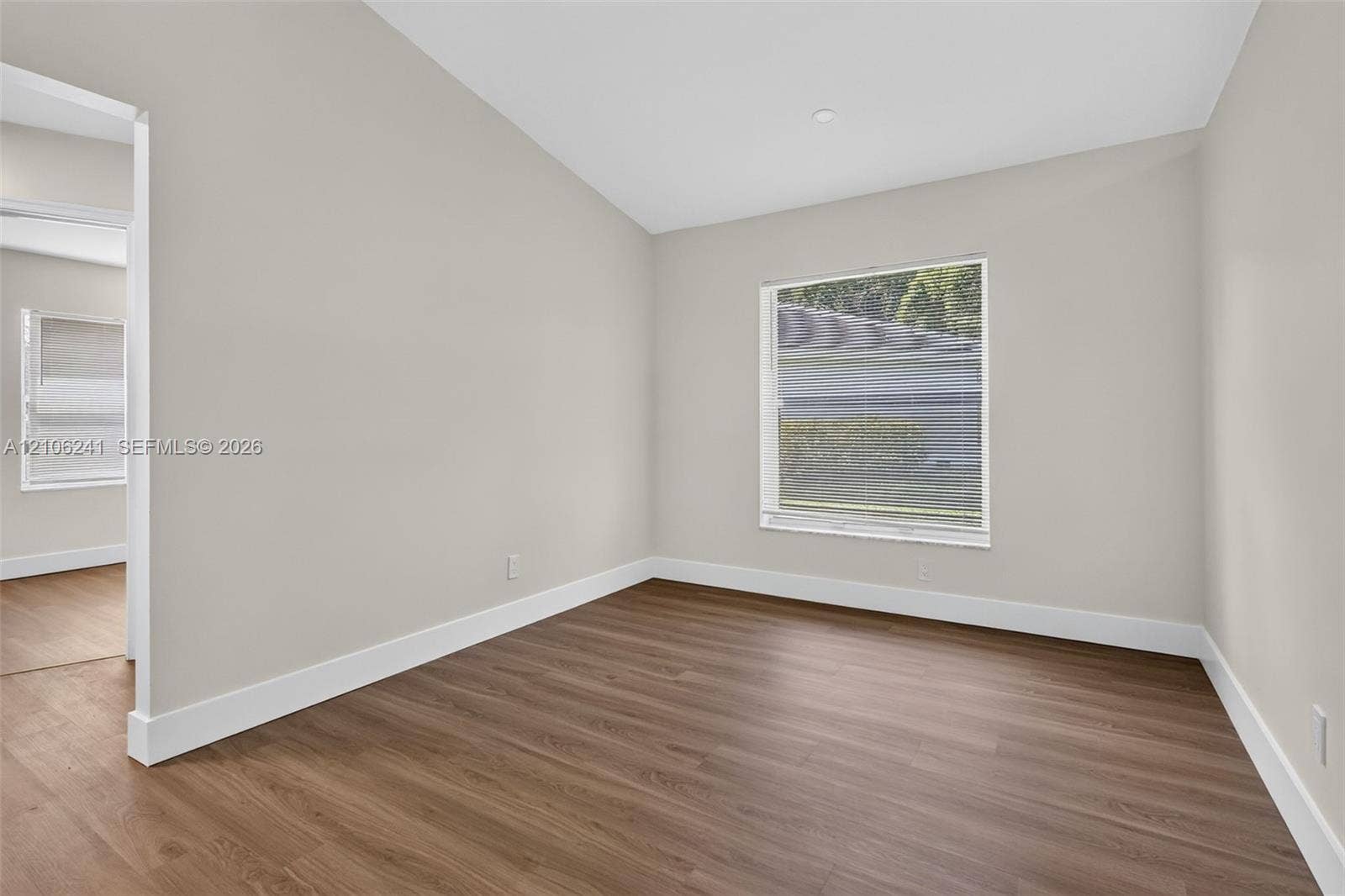 9407 SW 18th Street, Miramar, FL 33025 Neutral-toned interior room featuring wood-finish flooring, a vaulted ceiling, and recessed lighting
