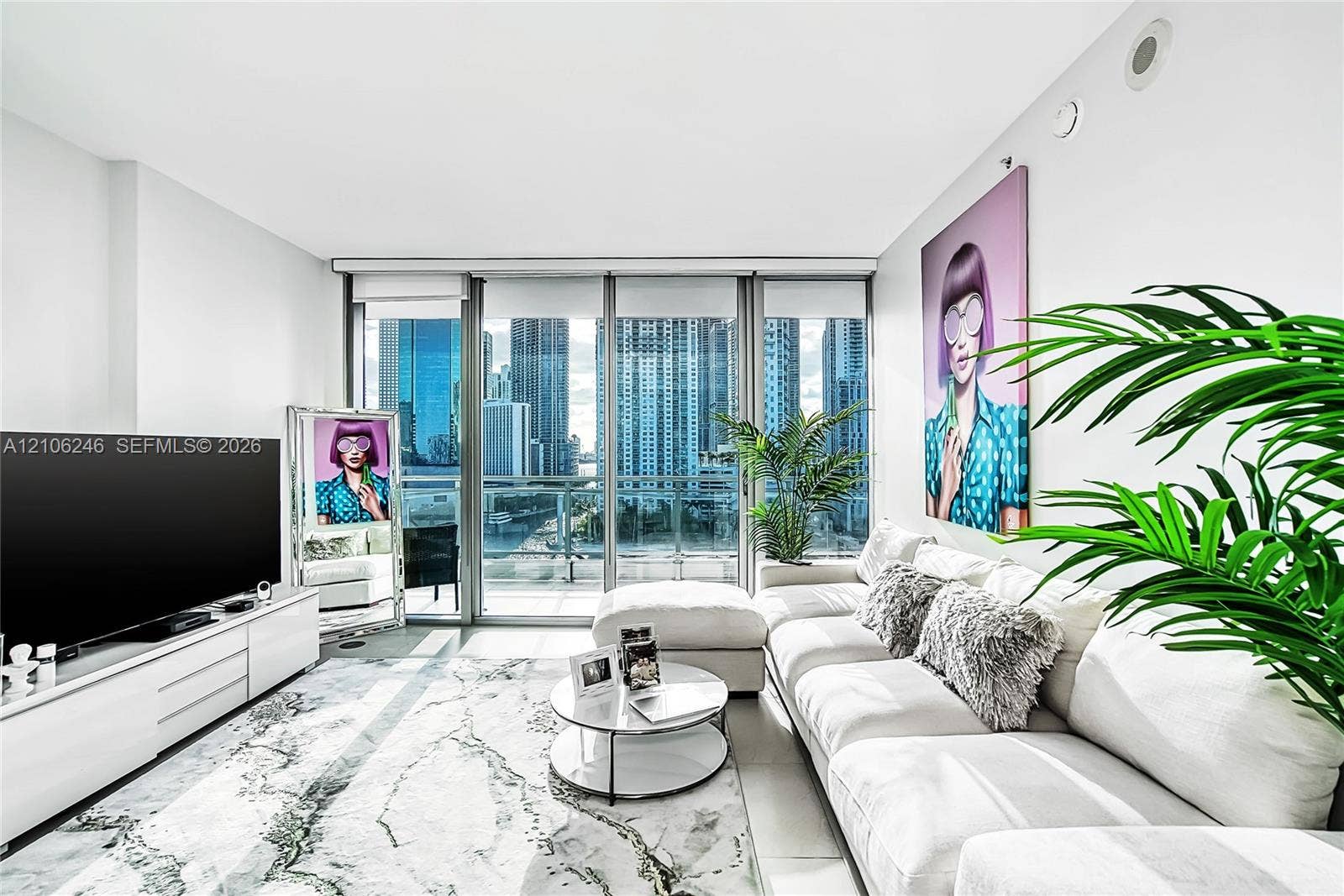 92 SW 3rd Street, #1511, Miami, Miami, FL 33130 Floor-to-ceiling glass paneling, high-rise urban landscape, light-reflecting tile flooring, and custom white built-in media console