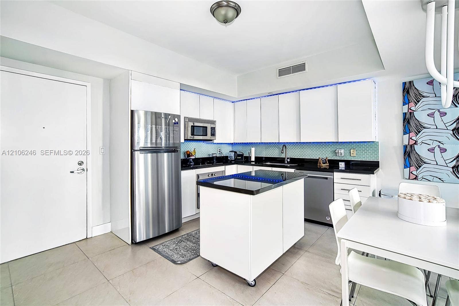 92 SW 3rd Street, #1511, Miami, Miami, FL 33130 Kitchen featuring white flat-panel cabinetry, dark stone countertops, stainless steel appliances, a mobile center island, and tiled backsplash