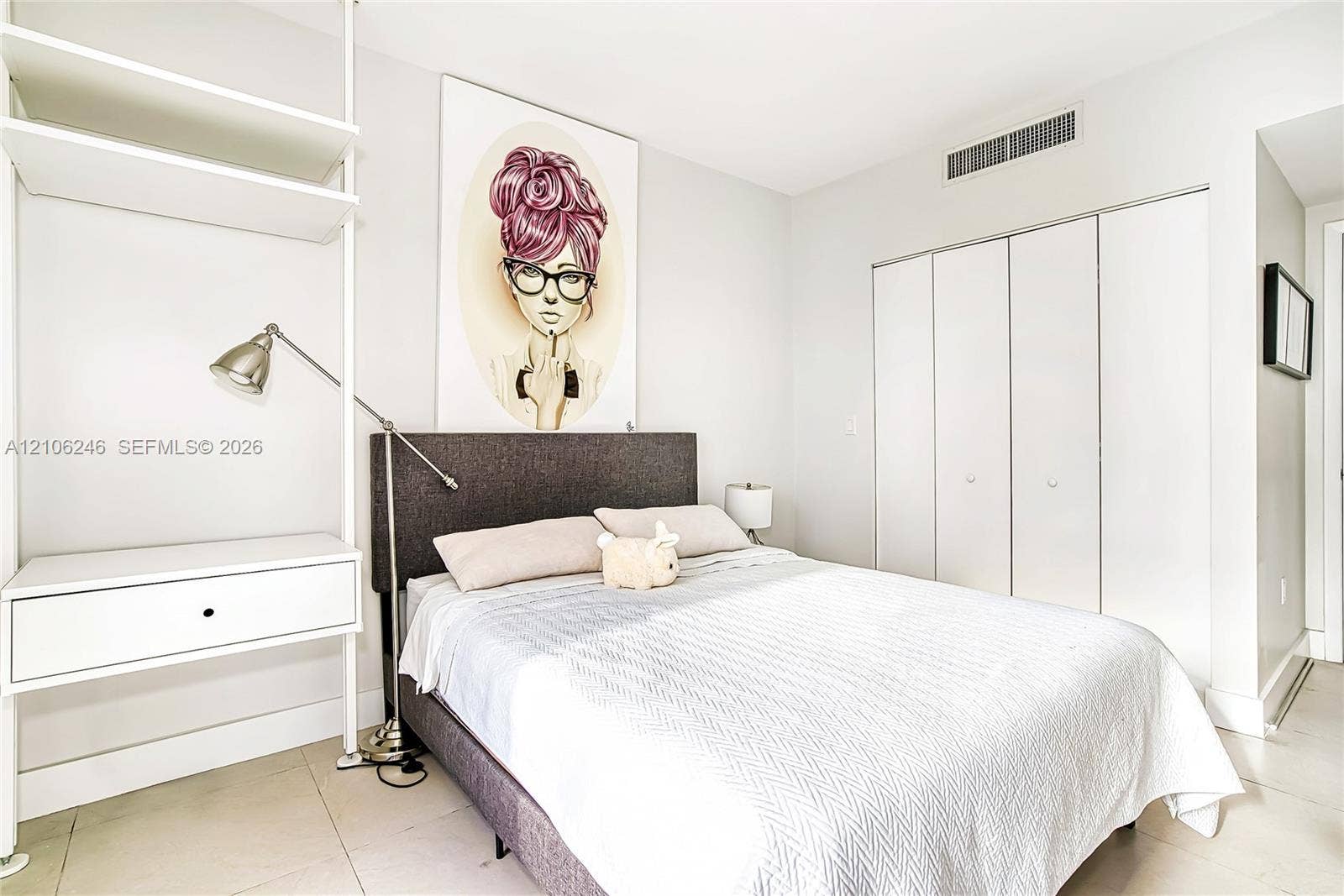 92 SW 3rd Street, #1511, Miami, Miami, FL 33130 Built-in white shelving unit with integrated desk surface, tile flooring, and closet featuring white bifold doors