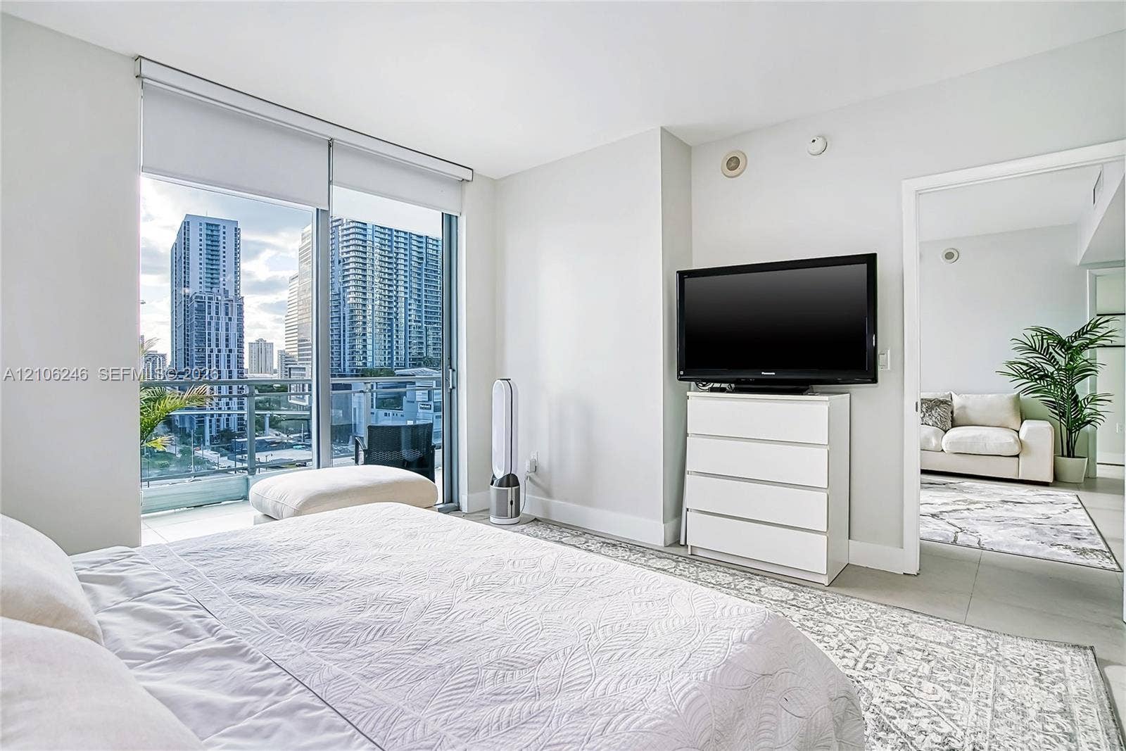 92 SW 3rd Street, #1511, Miami, Miami, FL 33130 Floor-to-ceiling glass sliding doors, private balcony, large-format tile flooring, and urban skyscraper backdrop