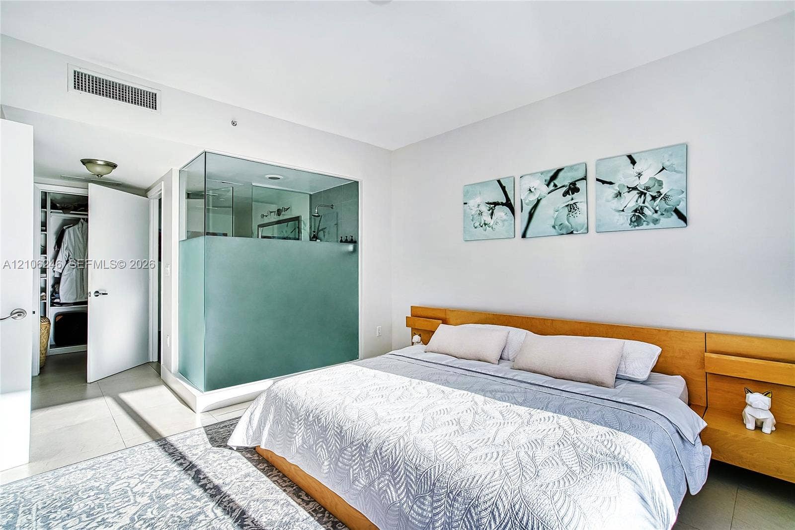 92 SW 3rd Street, #1511, Miami, Miami, FL 33130 Glass-enclosed shower featuring a frosted privacy panel, built-in wooden headboard with integrated shelving, and large-format tile flooring