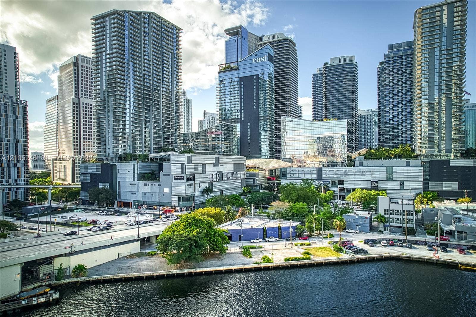 92 SW 3rd Street, #1511, Miami, Miami, FL 33130 High-rise urban center featuring glass-facade skyscrapers, concrete hardscaping, waterfront bulkhead, and mature canopy trees
