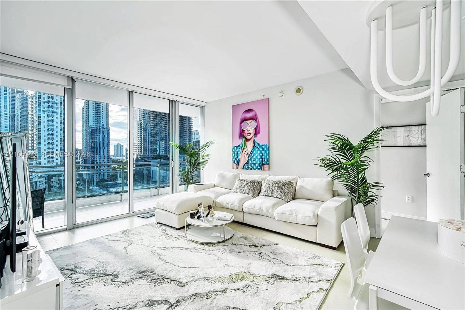 92 SW 3rd Street, #1511, Miami, Miami, FL 33130 Floor-to-ceiling glass wall, private balcony with glass railing, large-format tile flooring, and contemporary sculptural lighting fixture