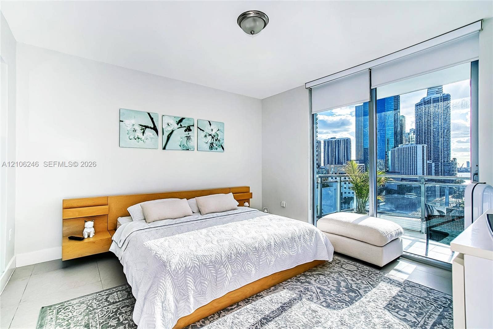 92 SW 3rd Street, #1511, Miami, Miami, FL 33130 Floor-to-ceiling glass wall, private balcony with metal railing, neutral tile flooring, and integrated wood-finish headboard