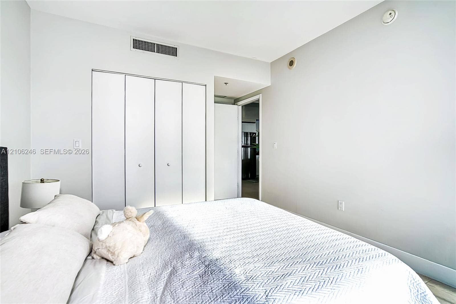 92 SW 3rd Street, #1511, Miami, Miami, FL 33130 Neutral-toned room featuring a four-panel bi-fold closet with brushed metal hardware and light-toned flooring
