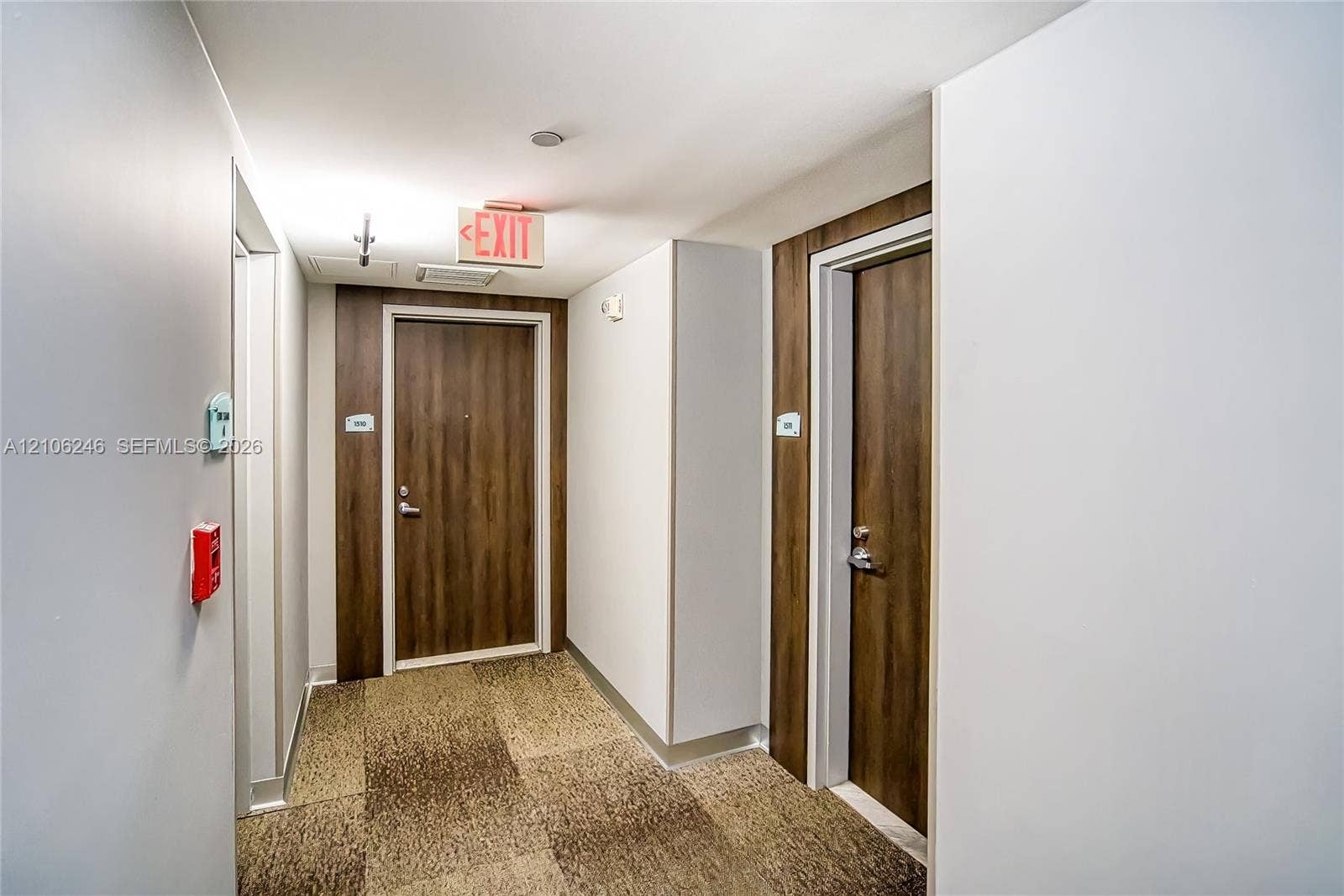 92 SW 3rd Street, #1511, Miami, Miami, FL 33130 Hallway featuring neutral wall finishes, tile-patterned carpeting, and wood-finish doors set within contrasting dark wood-toned surrounds