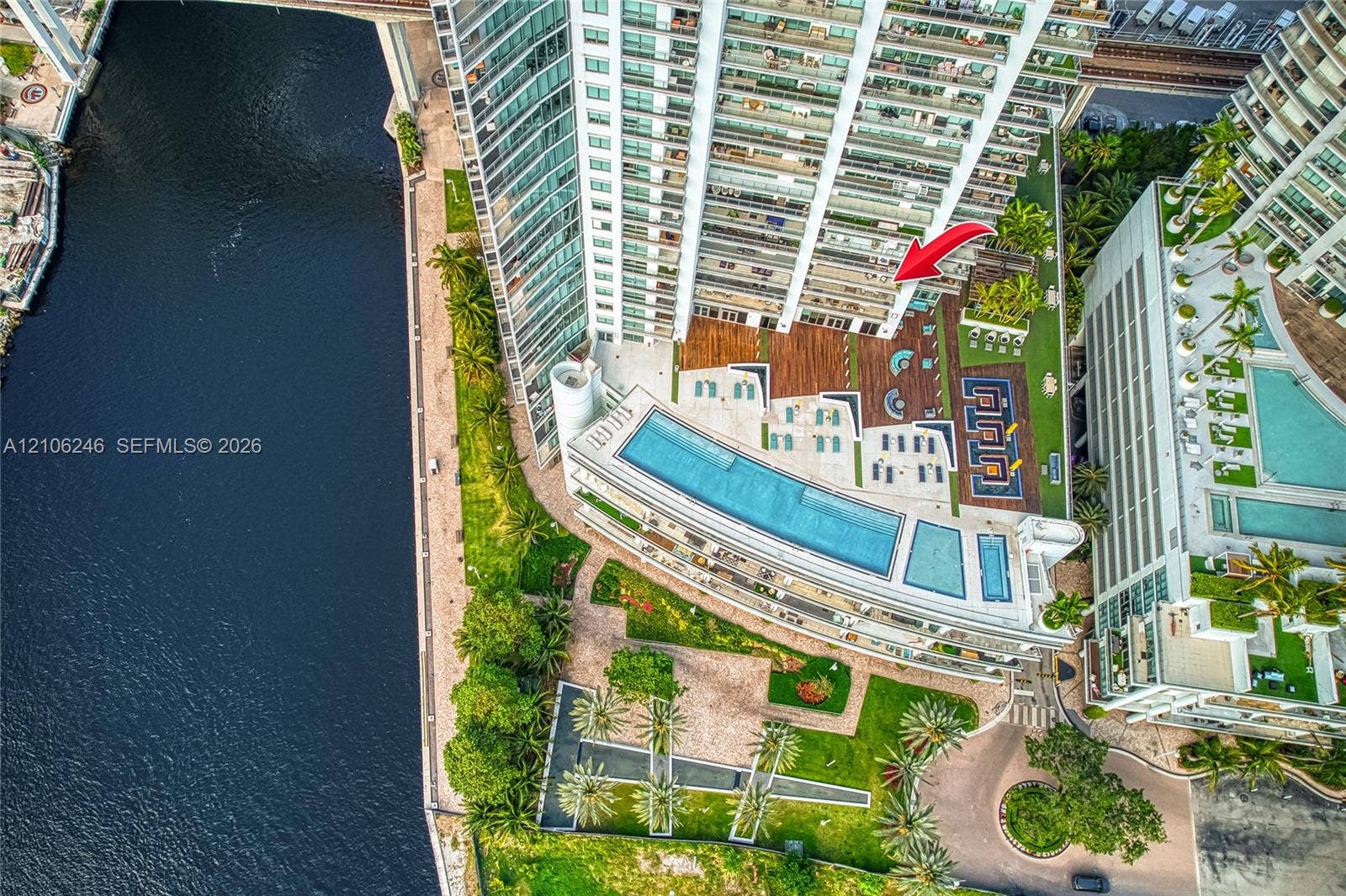 92 SW 3rd Street, #1511, Miami, Miami, FL 33130 High-rise property featuring an expansive outdoor recreation deck with a multi-level swimming pool, manicured lawn areas, wood-finish decking, and direct water frontage
