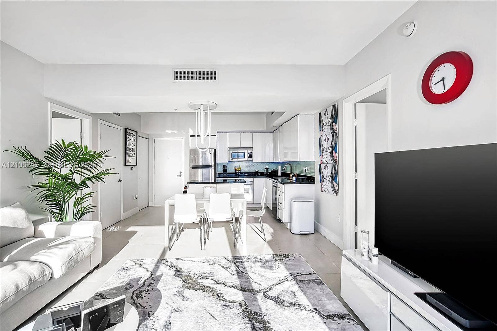 92 SW 3rd Street, #1511, Miami, Miami, FL 33130 Open-concept kitchen featuring high-gloss cabinetry, stone countertops, stainless steel appliances, and a central peninsula