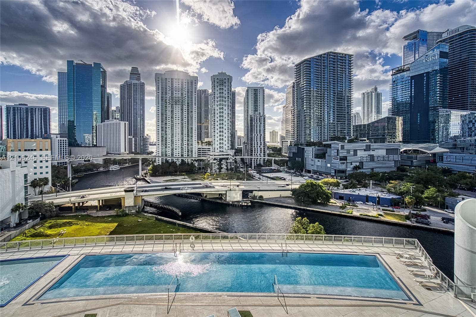 92 SW 3rd Street, #1511, Miami, Miami, FL 33130 Swimming pool with a paved deck, glass railing, and prominent metropolitan skyline backdrop