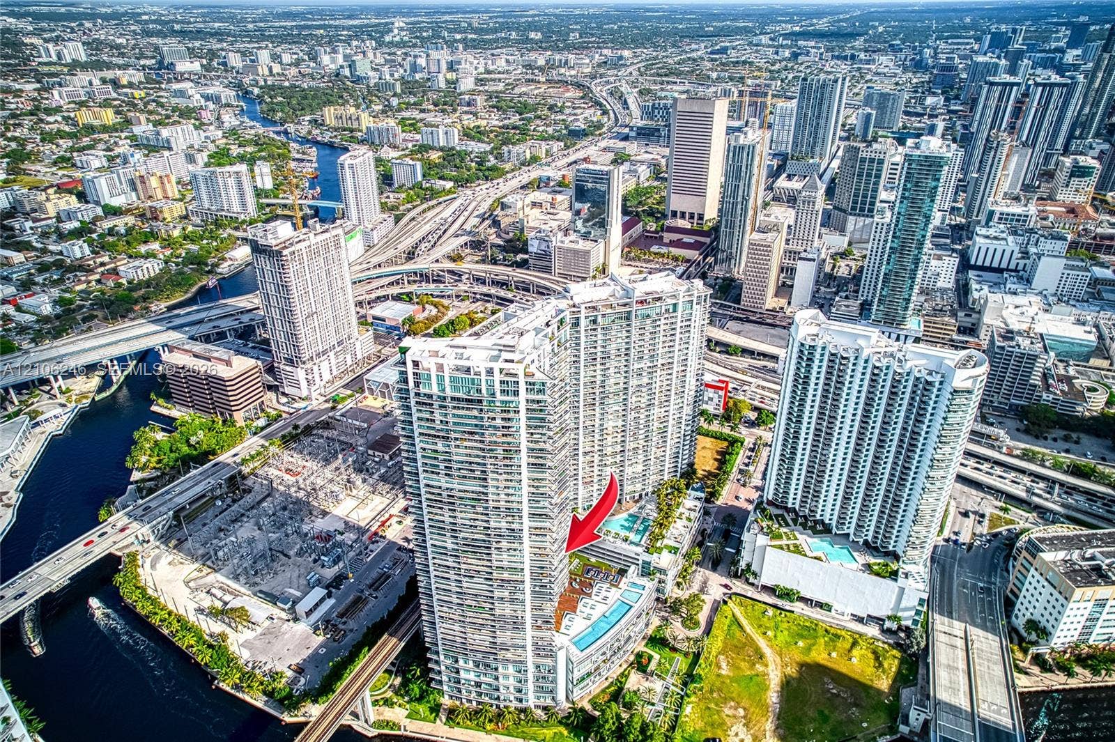 92 SW 3rd Street, #1511, Miami, Miami, FL 33130 Aerial perspective of high-rise building featuring expansive balcony space, glass exterior cladding, and proximity to urban infrastructure and waterways