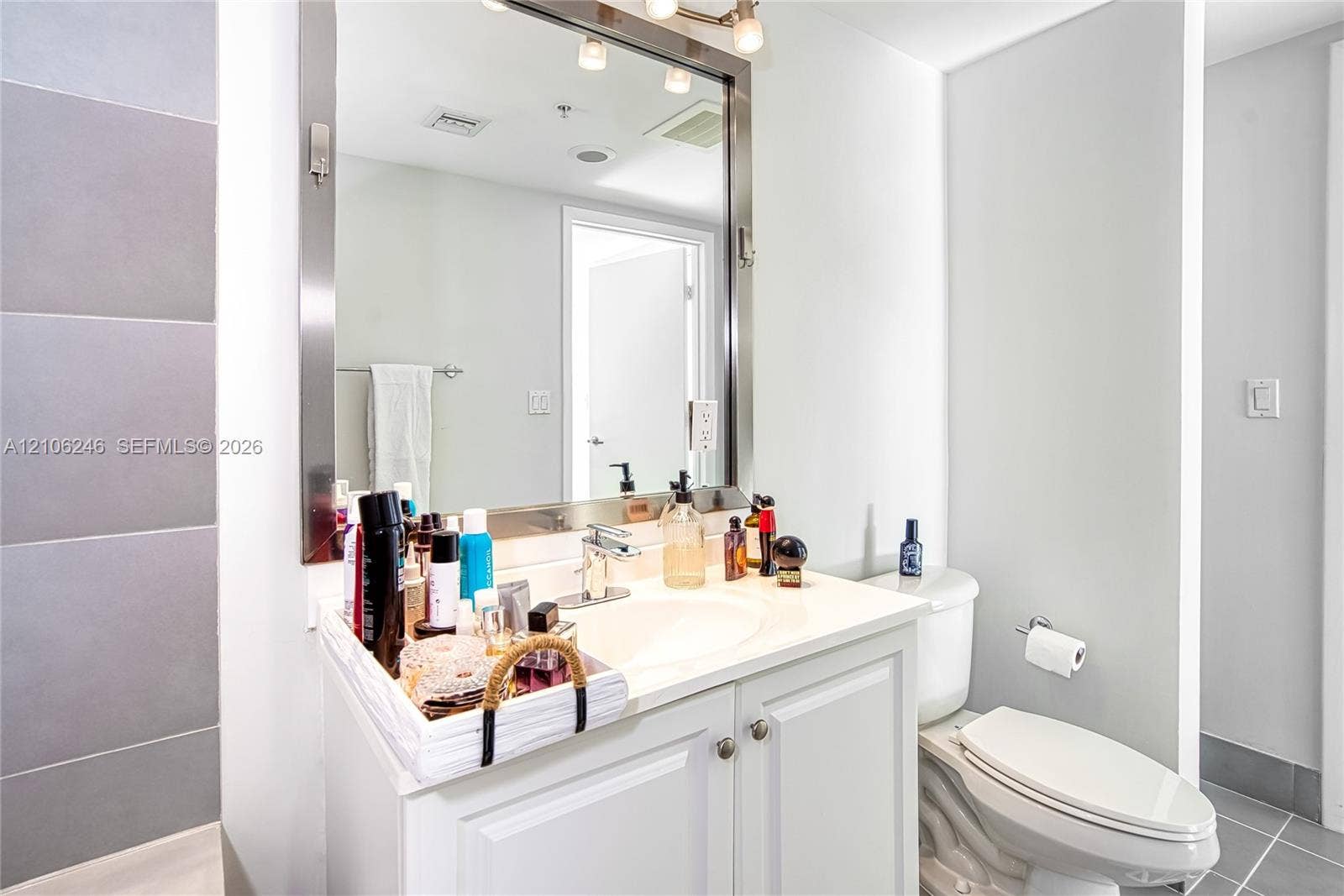 92 SW 3rd Street, #1511, Miami, Miami, FL 33130 Bathroom vanity featuring a solid-surface countertop, integrated basin, brushed metal faucet, and framed rectangular mirror with integrated lighting