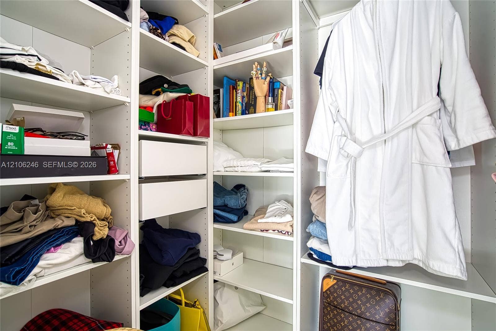 92 SW 3rd Street, #1511, Miami, Miami, FL 33130 Customized walk-in closet featuring floor-to-ceiling white shelving, integrated adjustable storage cubbies, and dual soft-close drawers