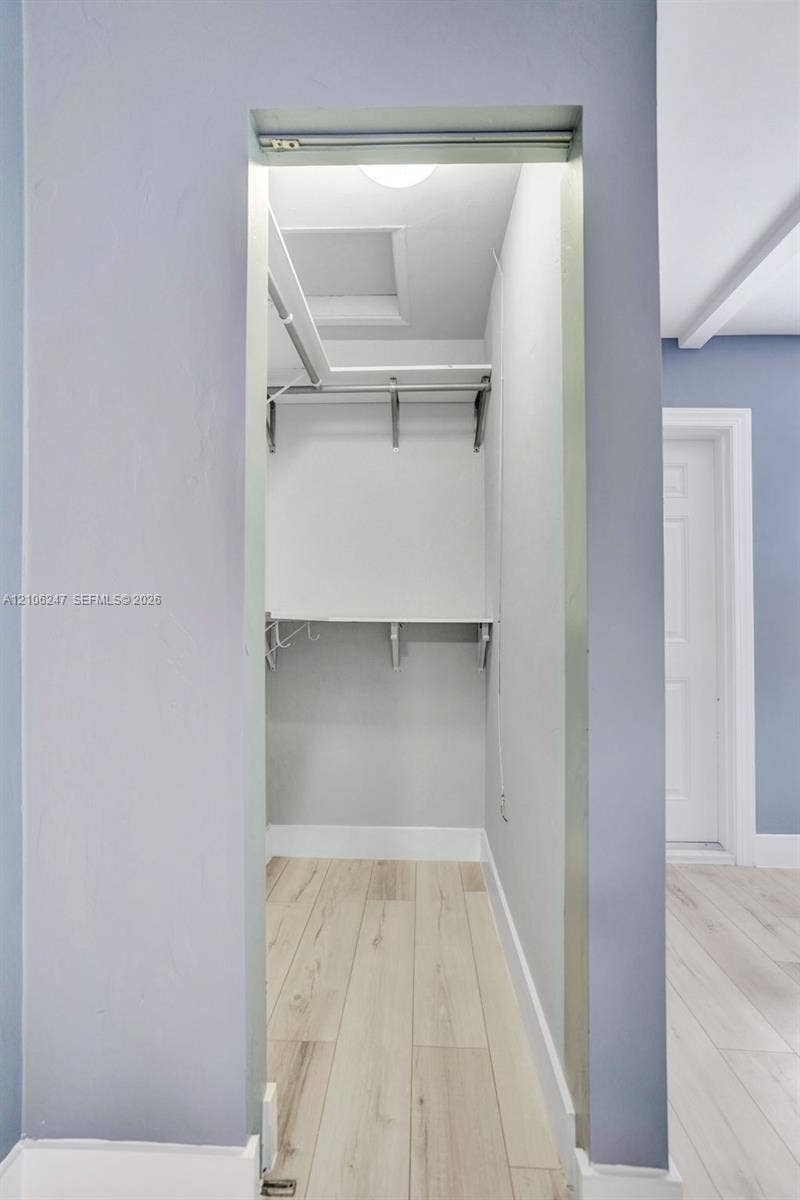 1037 N Victoria Park Road, #2, Fort Lauderdale, Fort Lauderdale, FL 33304 Reach-in closet featuring wood-finish flooring, white shelving, and a metal hanging rod