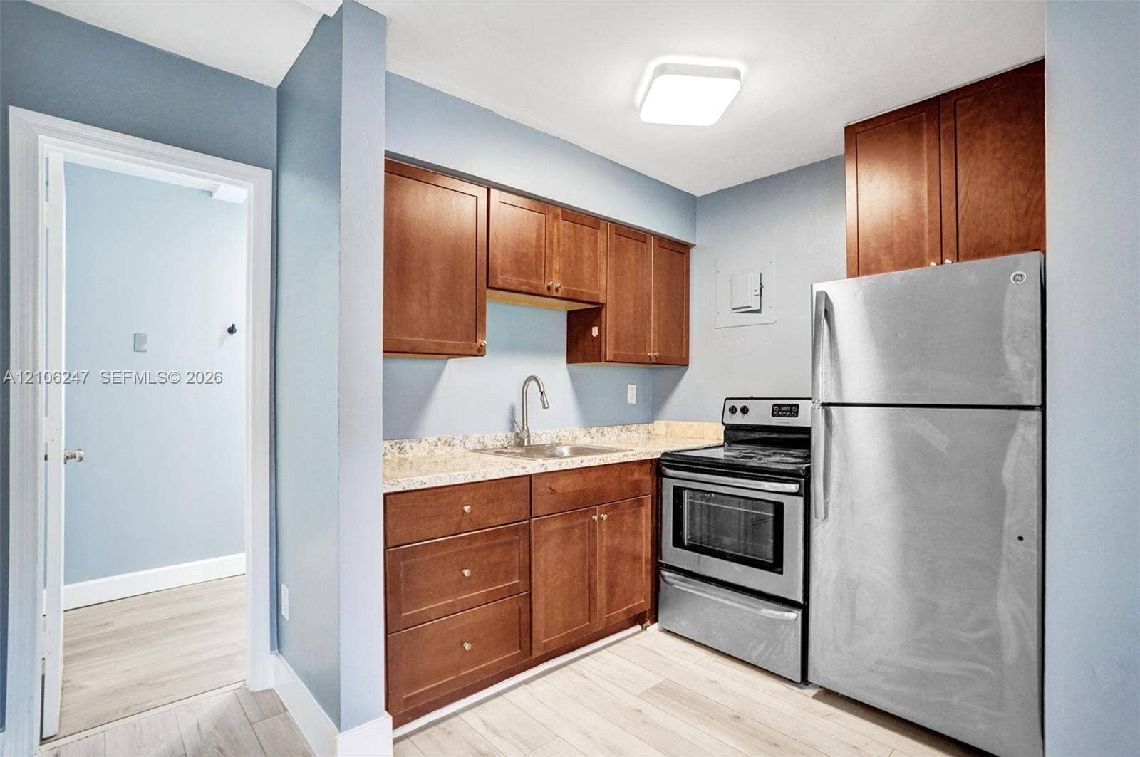1037 N Victoria Park Road, #2, Fort Lauderdale, Fort Lauderdale, FL 33304 Kitchen featuring natural wood cabinetry, stone-finish countertops, stainless steel appliances, and light-toned wood-finish flooring