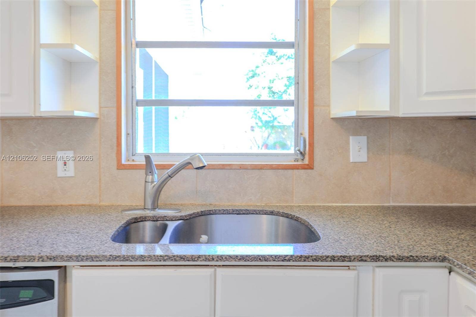 225 E Ilex Drive, Lake Park, Lake Park, FL 33403 Kitchen featuring stone-finish countertops, stainless steel undermount sink with a gooseneck faucet, light-toned ceramic tile backsplash, and white cabinetry with open shelving