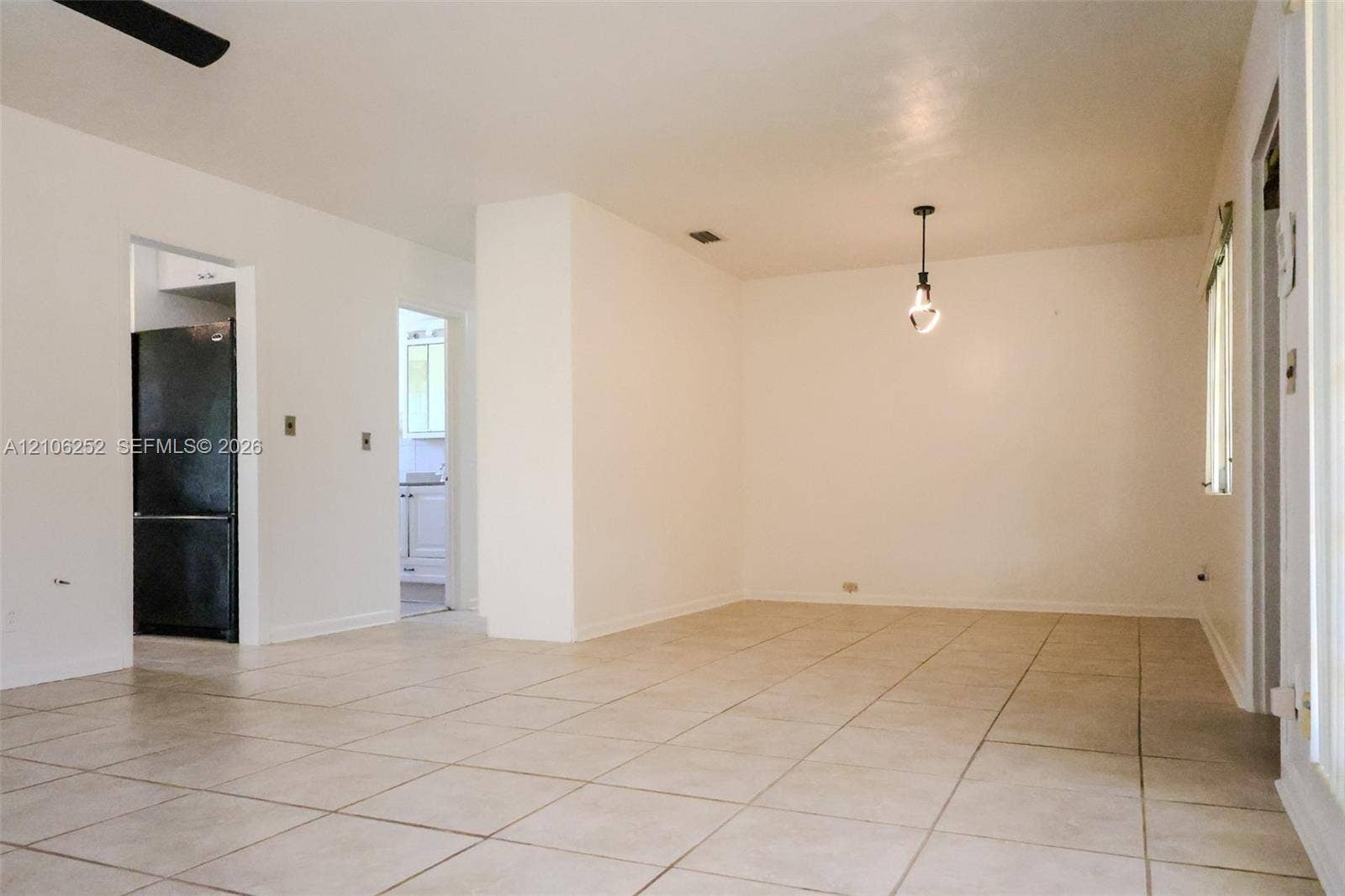 225 E Ilex Drive, Lake Park, Lake Park, FL 33403 Interior space featuring light-toned tile flooring, neutral wall paint, and a hanging pendant light fixture