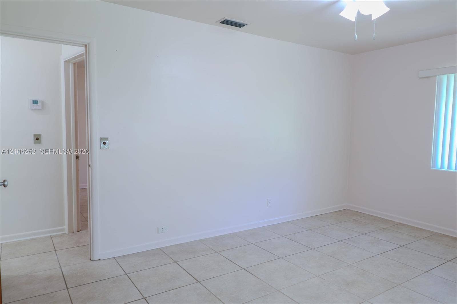225 E Ilex Drive, Lake Park, Lake Park, FL 33403 Neutral-toned ceramic tile flooring, ceiling-mounted light fixture with fan, and vertical window blinds