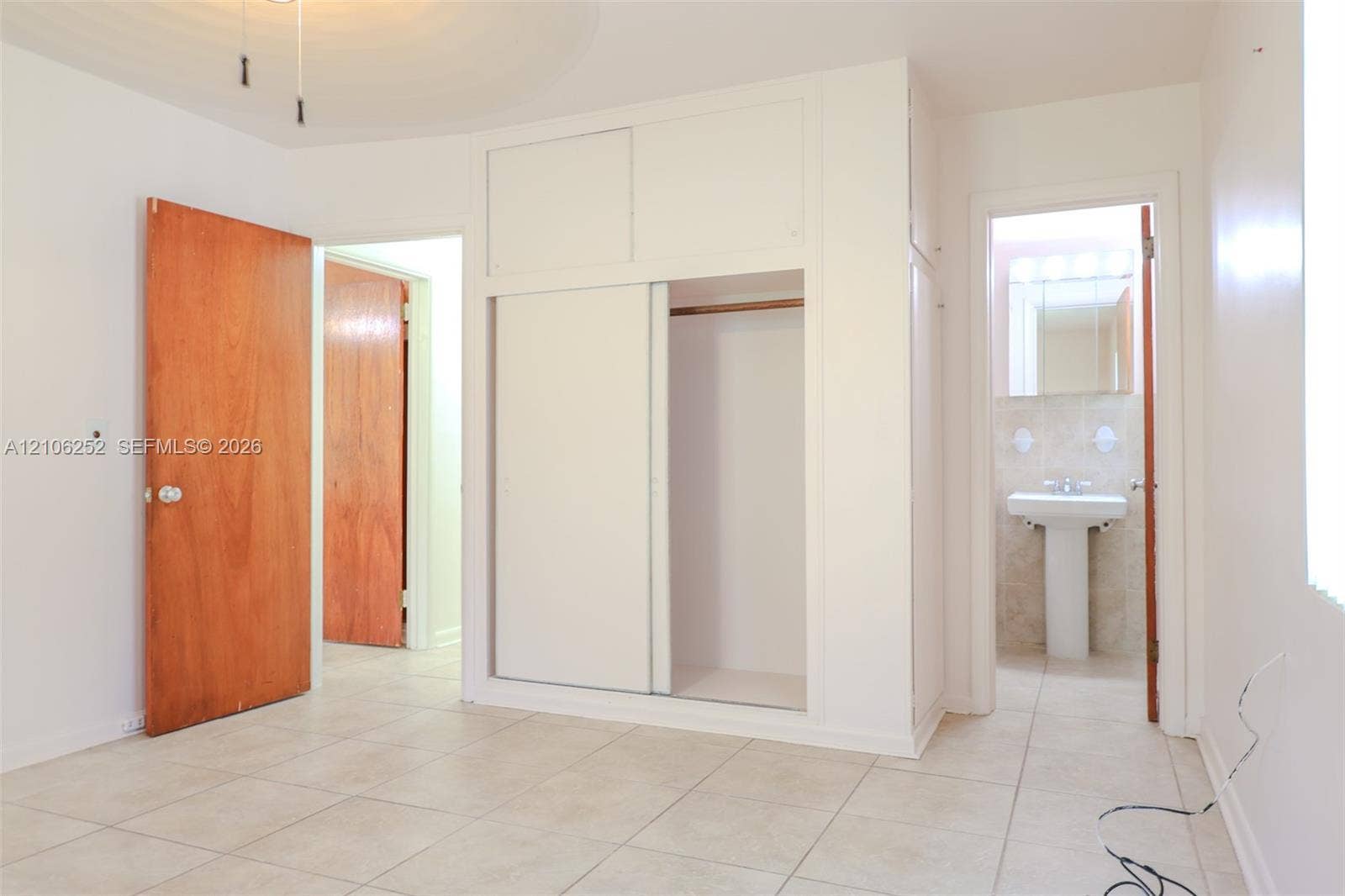 225 E Ilex Drive, Lake Park, Lake Park, FL 33403 Ceramic tile flooring, built-in floor-to-ceiling closet with sliding doors, and solid wood-finish interior doors