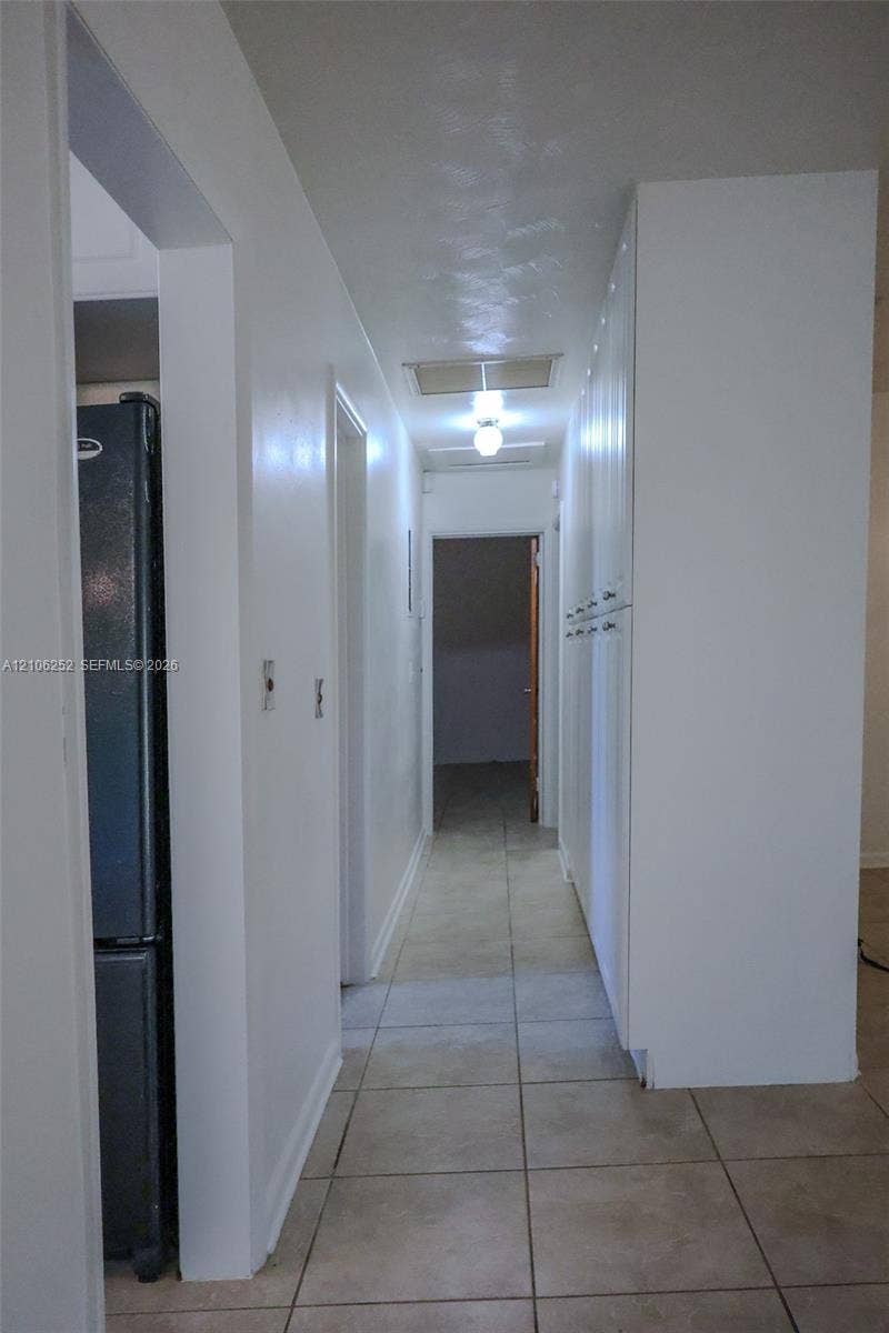 225 E Ilex Drive, Lake Park, Lake Park, FL 33403 Hallway featuring tile flooring, ceiling-mounted lighting, and floor-to-ceiling built-in white cabinetry
