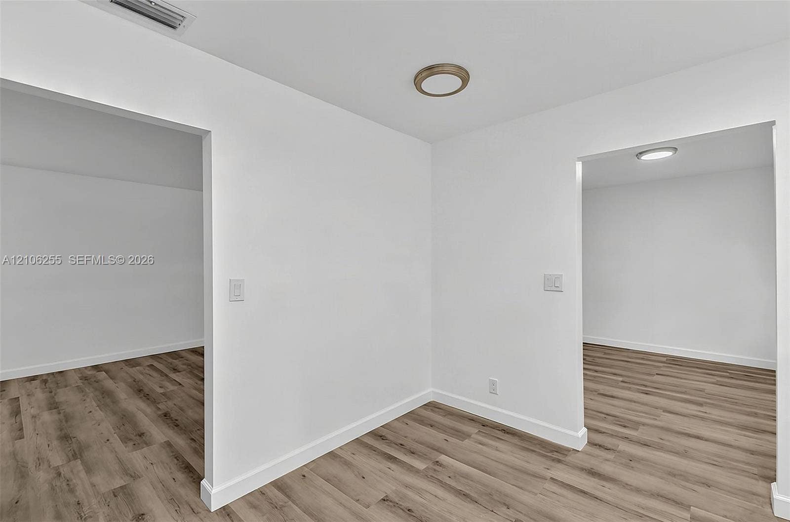 6118 Dusenburg Road, Delray Beach, FL 33484 Neutral interior featuring wood-finish flooring, white walls, and flush-mount ceiling lighting