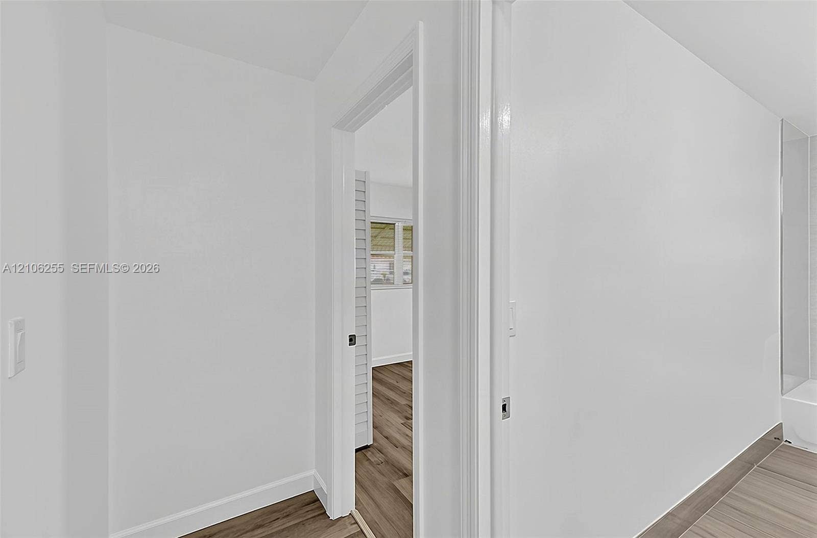 6118 Dusenburg Road, Delray Beach, FL 33484 Interior space featuring wood-finish flooring, white walls, louvered closet doors, and tile flooring