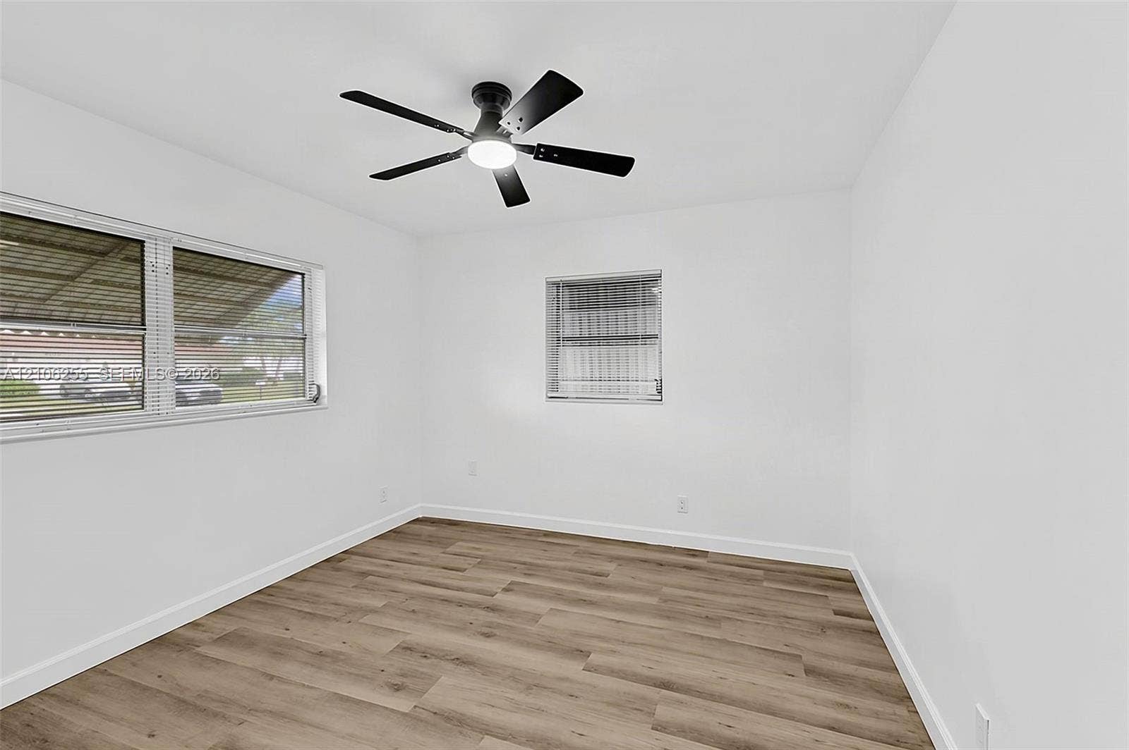6118 Dusenburg Road, Delray Beach, FL 33484 Room featuring wood-finish flooring, white walls, and a multi-blade ceiling fan with integrated lighting