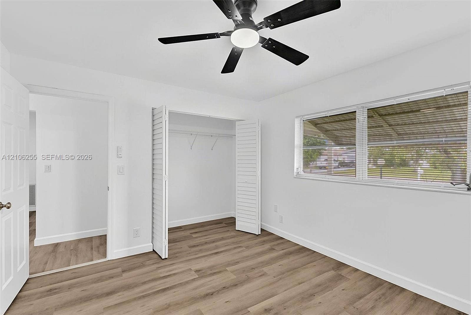 6118 Dusenburg Road, Delray Beach, FL 33484 Room interior featuring wood-finish flooring, a ceiling fan with integrated lighting, and a closet with bifold louvered doors