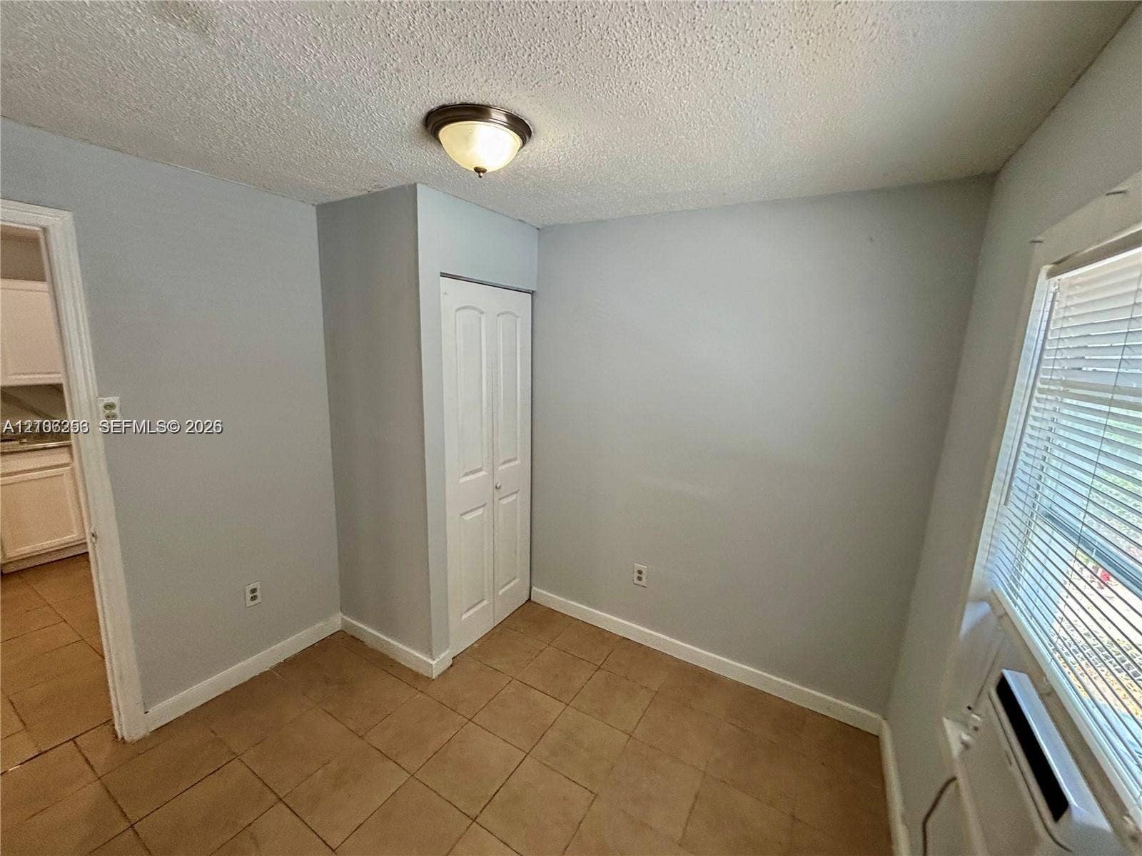 820 21st Street, West Palm Beach, FL 33407 Room featuring ceramic tile flooring, a dual-panel closet door, and a flush-mount ceiling light fixture