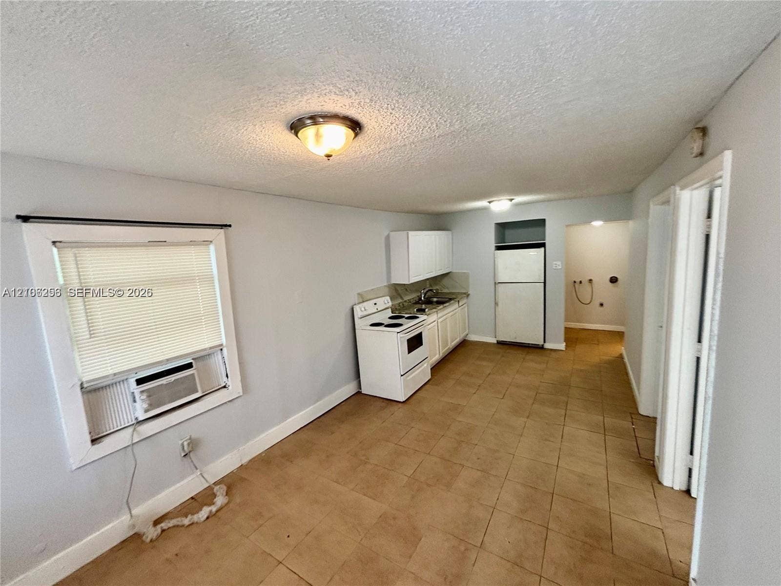 820 21st Street, West Palm Beach, FL 33407 Kitchen featuring ceramic tile flooring, white cabinetry, a white freestanding range, and an integrated refrigerator