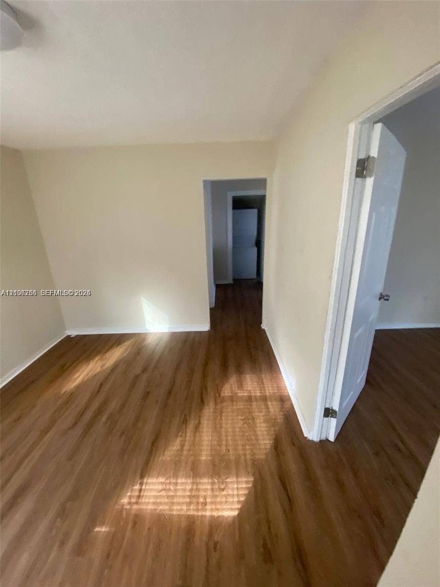 820 21st Street, West Palm Beach, FL 33407 Interior space featuring wood-finish flooring, neutral wall tones, and white interior doors with metallic hardware