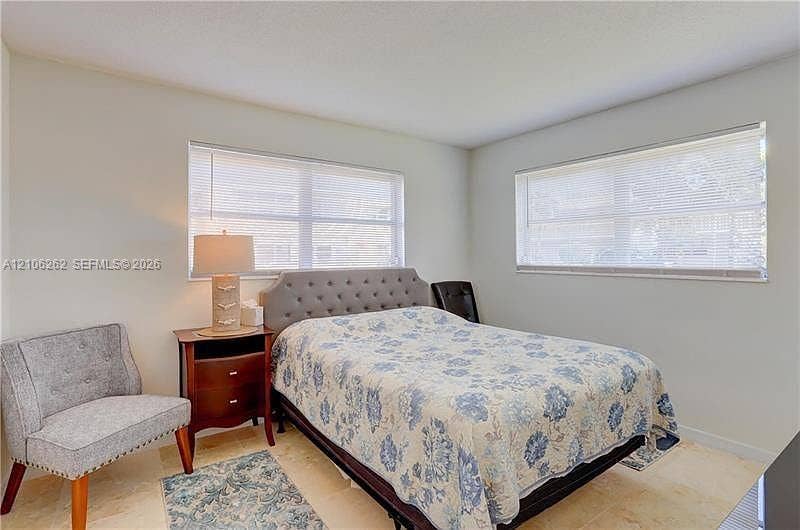 2212 NE 1st Way, #101, Boynton Beach, FL 33435 Neutral interior space featuring polished stone flooring and two large windows with horizontal blinds