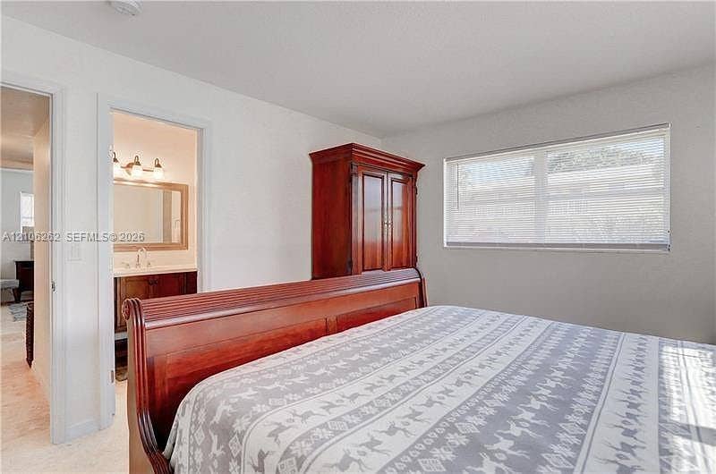 2212 NE 1st Way, #101, Boynton Beach, FL 33435 Neutral wall tones, horizontal window blinds, and interior door frame with overhead lighting fixture