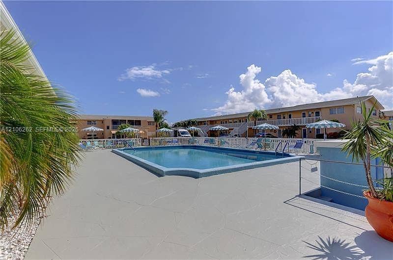 2212 NE 1st Way, #101, Boynton Beach, FL 33435 In-ground swimming pool with a concrete deck, perimeter metal fencing, and integrated landscaping