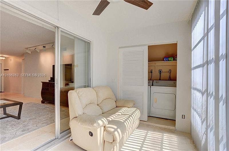 2212 NE 1st Way, #101, Boynton Beach, FL 33435 Enclosed patio featuring sliding glass doors, louvered closet doors, integrated laundry hookups, and a ceiling fan
