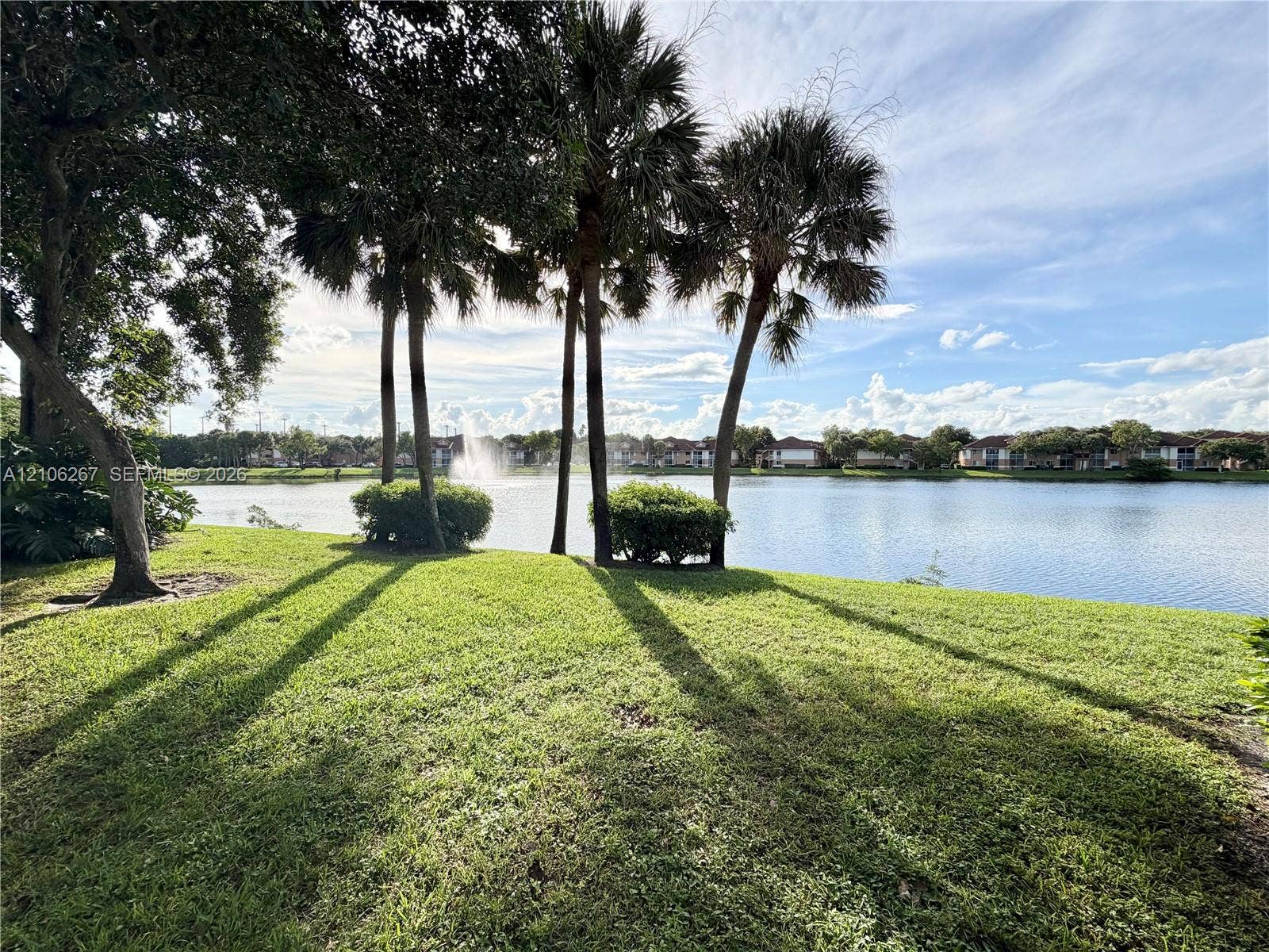 Screened-in lanai featuring a solid-surface floor, ceiling fan, and lake frontage