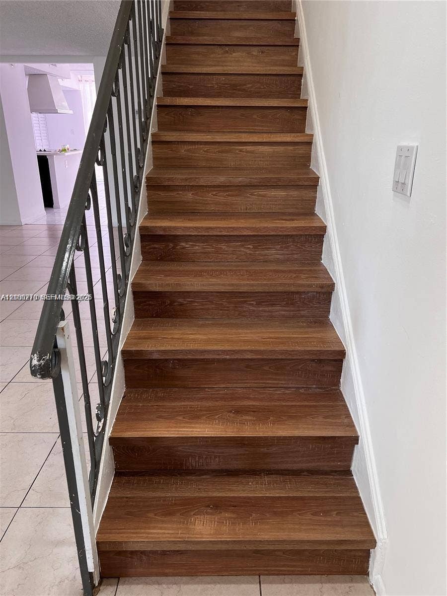 2410 NE 10th Street, #123, Hallandale Beach, Hallandale Beach, FL 33009 Staircase featuring wood-finish treads and a decorative metal railing