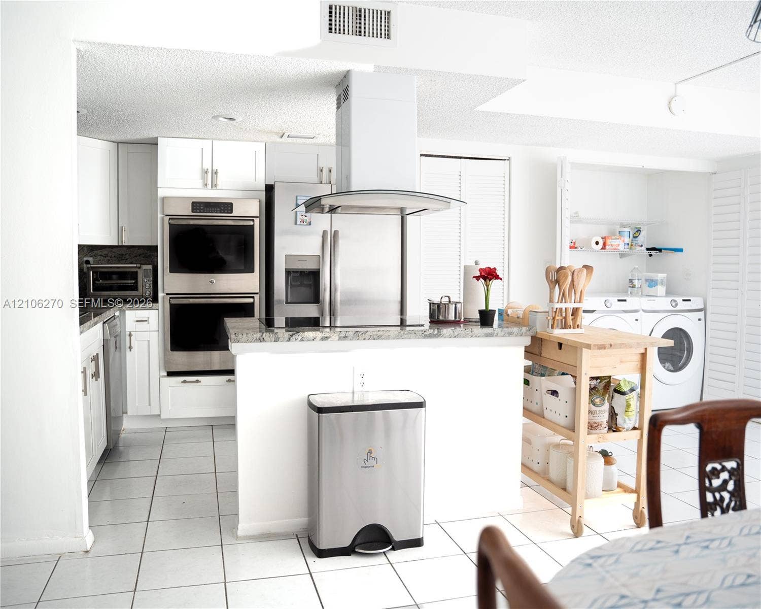 2410 NE 10th Street, #123, Hallandale Beach, Hallandale Beach, FL 33009 Kitchen featuring white cabinetry, stone-finish countertops, stainless steel wall-mounted double oven, overhead exhaust hood, and white tile flooring
